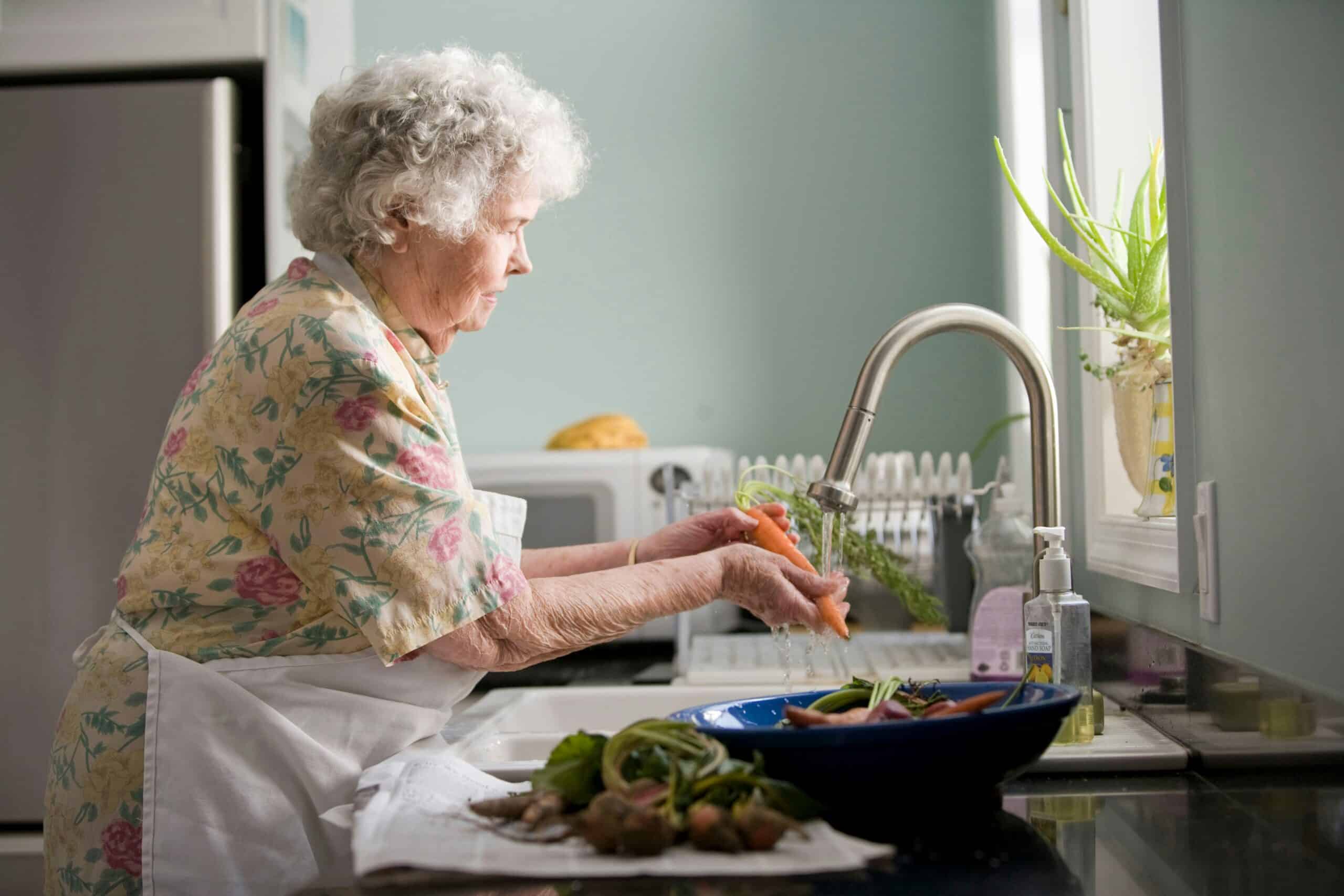 woman washing vegetables in the sink